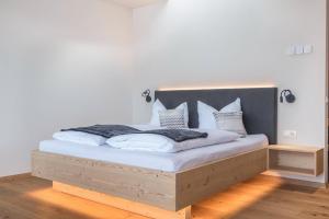 a bedroom with a bed with white sheets and pillows at Aura Chalets - Nr 2 in Castelrotto