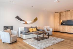 a living room with a couch and two chairs and a table at Aura Chalets - Nr 2 in Castelrotto
