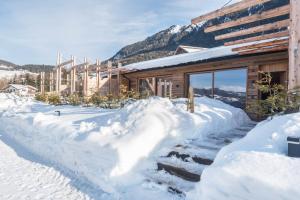 a log cabin in the snow with mountains in the background at Aura Chalets - Nr 2 in Castelrotto