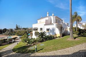 a white house with a palm tree in front of it at Casa Primavera in Carvoeiro