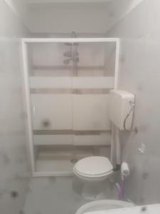 a white bathroom with a toilet and a shower at Elena's Guest House in Urbino