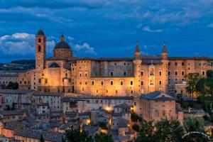 a large castle in a city at night at Elena's Guest House in Urbino