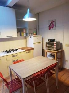 a kitchen with a table and a stove and a microwave at Elena's Guest House in Urbino +24 photos