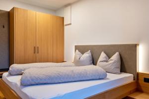a bedroom with two beds and a cabinet at Ferienwohnungen Karin - Lagrein in Termeno
