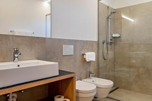 a bathroom with a sink and a toilet and a shower at Ferienwohnungen Karin - Lagrein in Termeno +19 photos
