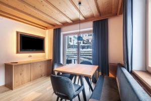 a dining room with a table and chairs and a window at La Grambla App Sella in Santa Cristina Gherdëina