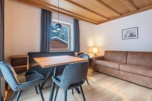 a living room with a table and chairs and a couch at La Grambla App Sella in Santa Cristina Gherdëina