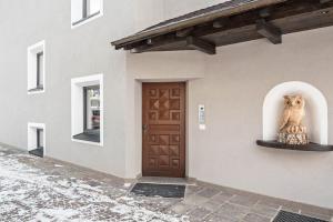a building with an owl statue next to a door at La Grambla App Sella in Santa Cristina Gherdëina