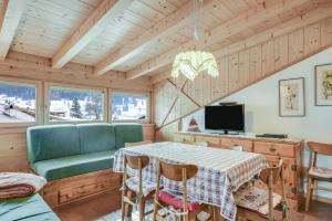 a dining room with a table and a couch at Ciasa Christina - Attic in Moena