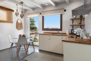 a kitchen with white cabinets and a table and chairs at Apartamento Romero in Arrecife