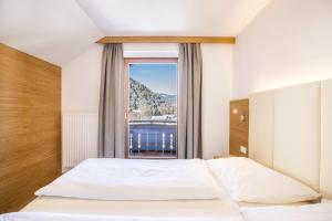 a bedroom with a bed and a large window at Rosalpina Apt 3 in San Vigilio Di Marebbe
