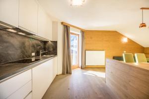 a kitchen with white cabinets and a counter top at Rosalpina Apt 3 in San Vigilio Di Marebbe