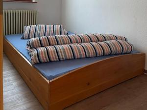 a wooden bed with two pillows on top of it at Ferienwohnung Käppeler in Salem +5 photos