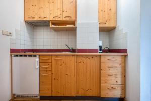 a kitchen with wooden cabinets and a white refrigerator at Lindenhof Apt 7 in Vandoies +11 photos