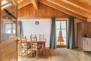 a kitchen with a table and chairs and a window at Apartment Ferienhaus Huber in Grainau