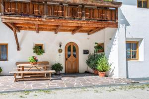 a house with a wooden door and a wooden bench at Lindenhof Apt 7 in Vandoies
