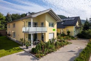 a yellow house with a balcony and some plants at Im Rosengarten in Zell am Harmersbach