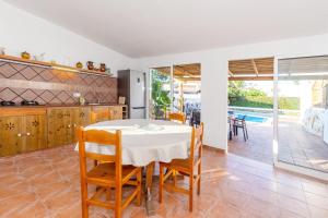 a kitchen and dining room with a table and chairs at Chalet Es Llossar in Cala en Blanes