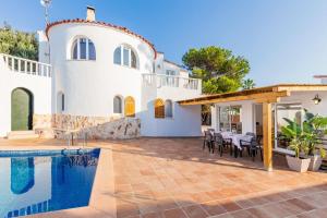 a villa with a swimming pool and a house at Chalet Es Llossar in Cala en Blanes