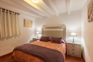 a bedroom with a bed with two night stands and two lamps at Casa Victor - Apartment 2 in La Orotava +14 photos