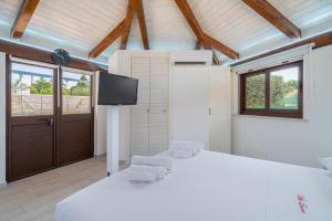 a bedroom with a bed and two chairs and a tv at Villa Luana con piscina in Noto +44 photos