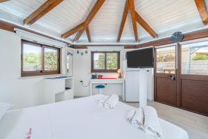 a white room with a bed and a tv at Villa Luana con piscina in Noto