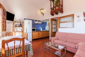 a living room with a pink couch and a kitchen at Casa Victor - Apartment 2 in La Orotava
