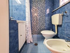 a blue tiled bathroom with a toilet and a sink at Il Borgo 5 in Capoliveri +11 photos