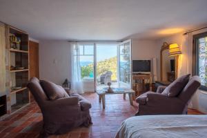 a living room with two chairs and a couch and a television at La Maison de Constance in Cavalaire-sur-Mer