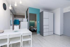 a kitchen with a white table and white cabinets at Location Noly in Seignosse