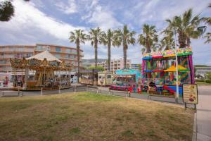 a carnival ride and a carousel in a park with palm trees at La Maison de Constance in Cavalaire-sur-Mer