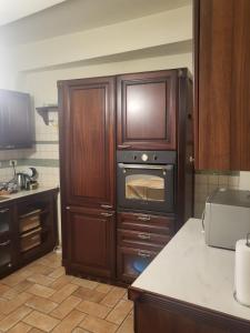 a kitchen with wooden cabinets and an oven at Elena's Guest House in Urbino