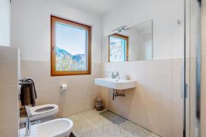 a bathroom with a sink and a toilet and a mirror at Ferienwohnung 3 Weger in Andrian +24 photos