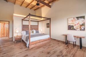 a bedroom with a bed and a table and a desk at Stunning villa w pool & mountain view in Jarabacoa in Jarabacoa