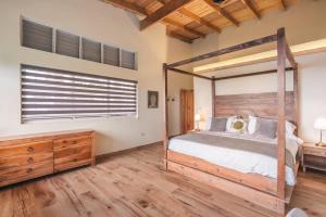 a bedroom with a canopy bed and a wooden dresser at Stunning villa w pool & mountain view in Jarabacoa in Jarabacoa +69 photos