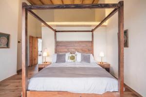 a bedroom with a wooden canopy bed with two lamps at Stunning villa w pool & mountain view in Jarabacoa in Jarabacoa