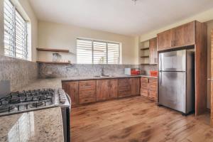 a kitchen with wooden cabinets and a stainless steel refrigerator at Stunning villa w pool & mountain view in Jarabacoa in Jarabacoa