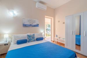 a bedroom with a blue bed and a window at Villa Leale Plemmirio con piscina in Syracuse