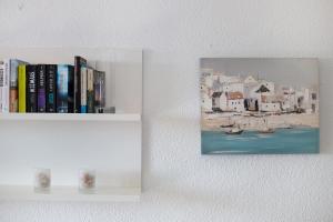 a shelf with books and a painting on a wall at Apartamento Cristobal in Morro del Jable