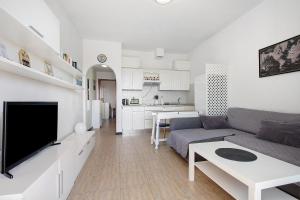 a living room with a couch and a flat screen tv at Apartamento Cristobal in Morro del Jable +12 photos