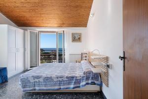 a bedroom with a bed with a view of the ocean at Attico Con Vista in Moneglia