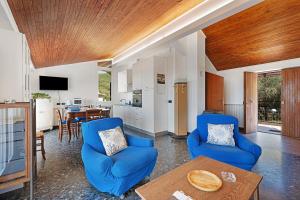 a living room with blue chairs and a table at Attico Con Vista in Moneglia