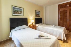 two beds in a hotel room with white sheets at Daniela in Pollença