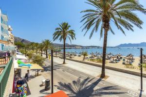 a view of a beach with palm trees and people at Daniela in Pollença