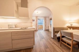a kitchen and a bedroom with a bed and a table at Residence Kronstein - Fewo 6 in Tesimo +7 photos