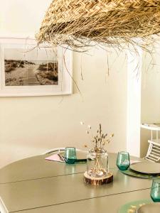 a table with glasses and a vase with flowers on it at T3 Moledo Com Piscina e Vista Mar in Moledo