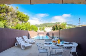 a patio with a table and chairs and a pool at T3 Moledo Com Piscina e Vista Mar in Moledo