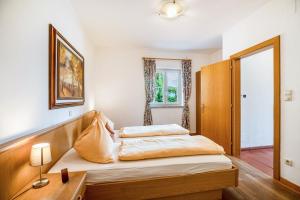 a bedroom with two beds and a wooden headboard at Weingut Lieselehof Apt Aurora in Caldaro