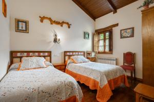 a bedroom with two beds and a chair at Maseda 1 in Villayón