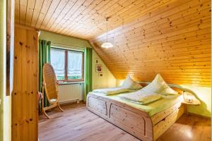 a bed in a room with a wooden ceiling at Furtwengler in Oberharmersbach